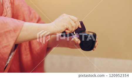 Japan, person or hands with cloth for tea ceremony, tradition or culture with scent, essence or aroma at home. Closeup, hostess and incense smell with fabric for traditional matcha, ritual or Chanoyu 120952354