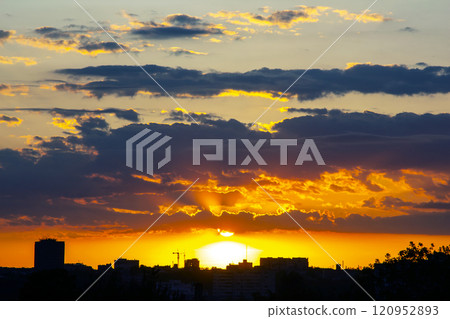 captivating twilight sky with bold streaks of orange and gold fading into a dark blue 120952893