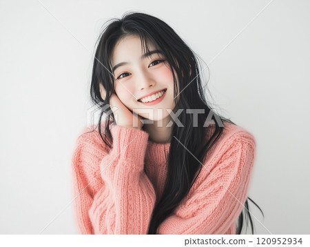 Girl in a pink sweater making a wish 120952934