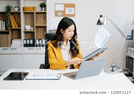 Business woman using tablet and laptop for doing math finance on an office desk, tax, report, accounting, statistics, 120953127