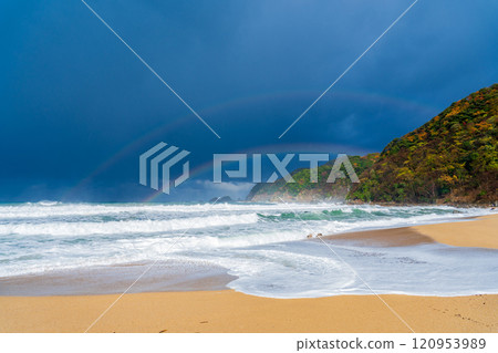 Kami Town, Hyogo Prefecture: Waves crashing on the beach and a rainbow in the stormy sky 120953989