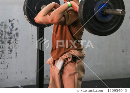 Weightlifting Athlete Performing Front Squat With Weights in a Gym Setting 120954043