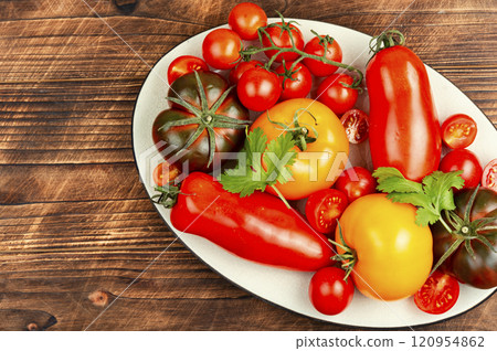 Ripe tomatoes on rustic wooden background. 120954862