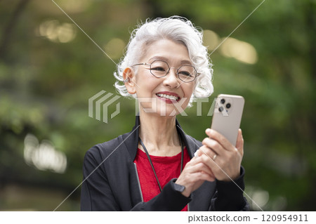 Smiling senior woman holding a smartphone Smiling senior woman holding a smartphone 120954911