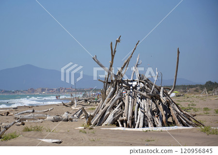 Washed up wood used to build wooden shelters against wind and sun on the beach near Marina di Grosseto, Tuscany, Italy Washed up wood used to build wooden shelters against wind and sun on the beach near Marina di Grosseto, Tuscany, Italy 120956845