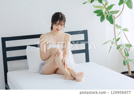 做腿的婦女護膚在床上 120956977