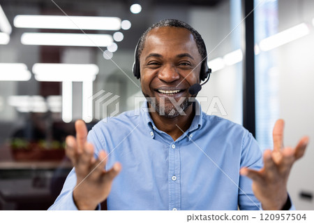 Cheerful African American businessman with headset in office setting displays confident communication and positive energy. Ideal for business, communication, and technology concepts. 120957504