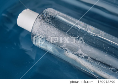 Bottle with cosmetic gel for face and body on blue background in water. 120958290