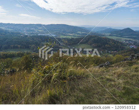 Panoramic view from viewpoint Stredni vrch near Dolni Prysk, Ceska Kamenice. Autumn landscape with colorful forest, hills and blue cloudy sky in Luzicke hory Lusatian Mountains, Czech Republic. Panoramic view from viewpoint Stredni vrch near Dolni Prysk, Ceska Kamenice. Autumn landscape with colorful forest, hills and blue cloudy sky in Luzicke hory Lusatian Mountains, Czech Republic. 120958312