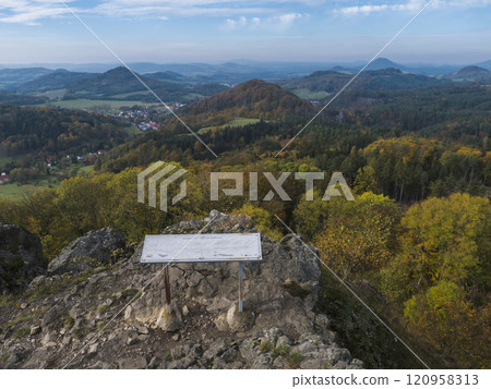 Panoramic view from viewpoint Stredni vrch near Dolni Prysk, Ceska Kamenice. Autumn landscape with colorful forest, hills and blue cloudy sky in Luzicke hory Lusatian Mountains, Czech Republic. Panoramic view from viewpoint Stredni vrch near Dolni Prysk, Ceska Kamenice. Autumn landscape with colorful forest, hills and blue cloudy sky in Luzicke hory Lusatian Mountains, Czech Republic. 120958313