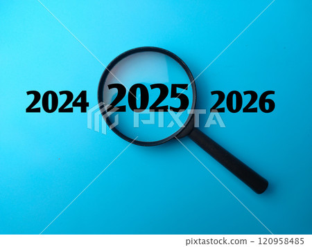 Magnifying glass and 2025 concept with word and blue background. Magnifying glass and 2025 concept with word and blue background. 120958485