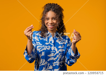 African teenager girl with money gesture, yellow studio. Rich smart lady smiling 120958715