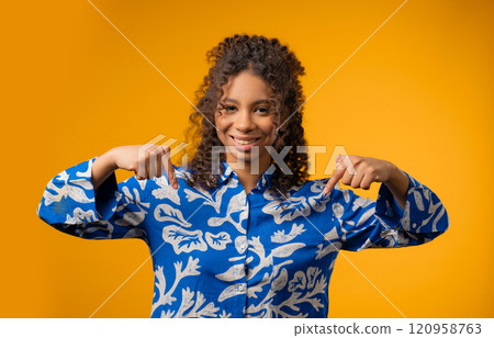 Charming woman pointing down advertising area.Yellow background. Click subscribe Charming woman pointing down advertising area.Yellow background. Click subscribe 120958763