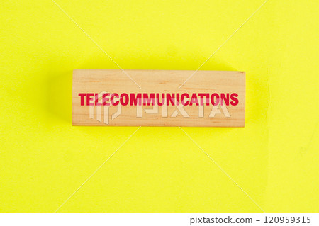 Wooden block with telecommunications written in bold red letters on a vibrant yellow background highlighting essential industry terminology Wooden block with telecommunications written in bold red letters on a vibrant yellow background highlighting essential industry terminology 120959315