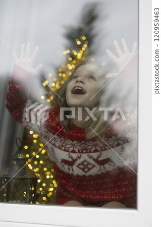 The girl in the window is waiting for a miracle. Christmas. The girl in the window is waiting for a miracle. Christmas. 120959463
