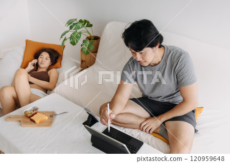 Couple lover, man working at home while woman is having a phone call. 120959648