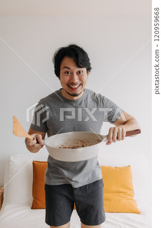 Vertical photo of happy man presents and offering his meal in the pan. Vertical photo of happy man presents and offering his meal in the pan. 120959668