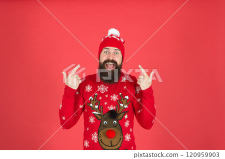 Hipster cheerful bearded man wear winter sweater and hat. Happy new year. Join holiday party craze and host ugly christmas sweater party. Feeling awesome. Buy festive clothing. Sweater with deer 120959903