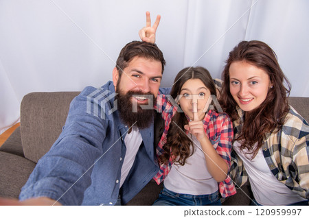 father mother and child on sofa. friendly family having fun. positive funny parents with kid 120959997