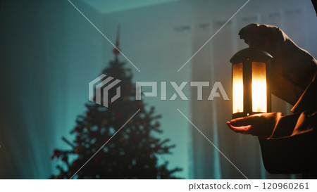 Vintage Lantern Of A Mysterious Man At Night In A Room With Unlit Christmas Tree Vintage Lantern Of A Mysterious Man At Night In A Room With Unlit Christmas Tree 120960261