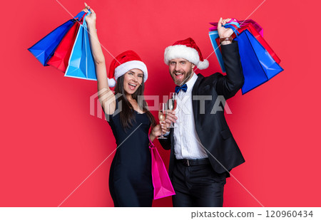 glad xmas shopaholic couple isolated on red. xmas shopping bags and shopaholic couple glad xmas shopaholic couple isolated on red. xmas shopping bags and shopaholic couple 120960434