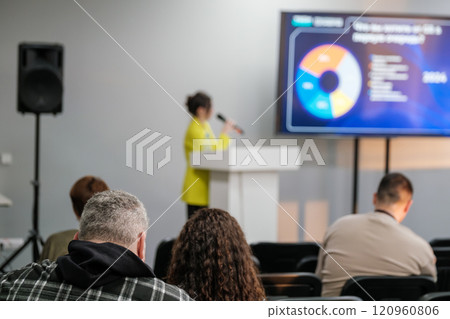 Business professional giving presentation during conference with attentive audience 120960806