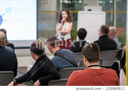 Audience attentively listening to a speaker at a professional business seminar Audience attentively listening to a speaker at a professional business seminar 120960811