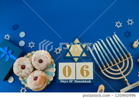 Jewish holiday Hanukkah concept. Frame of traditional jelly donuts and menorah on dark blue background 120960996