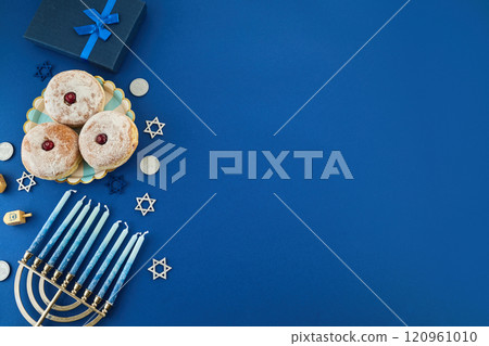 Jewish holiday Hanukkah concept. Frame of traditional jelly donuts and menorah on dark blue background 120961010