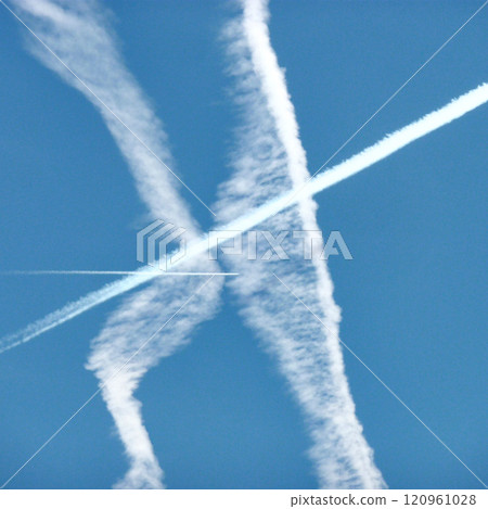 Gaseous trails of airplanes in the blue sky in Milan, Italy, in 2023.. 120961028