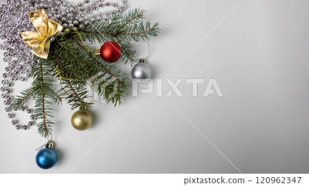 Christmas tree branches with small balls beads and a golden bow 120962347