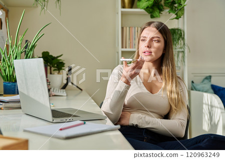 Young woman recording audio message on smartphone, at home Young woman recording audio message on smartphone, at home 120963249