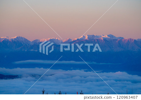[Winter material] The Southern Alps dyed in the morning glow as seen from Kirigamine in winter [Nagano Prefecture] 120963407