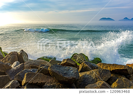 Waves crashing against breakwater 120963468