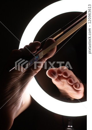 female legs with a violin bow in close-up in a round lamp. the concept of playing the violin .foot fetishism 120963613