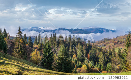 Late autumn mountain morning scene with snow covered tops in far and foggy clouds in valleys. Picturesque traveling, seasonal, nature and countryside beauty concept scene. Carpathians, Ukraine. 120963911