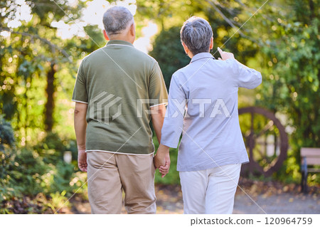 Rear view of a senior couple holding hands 120964759