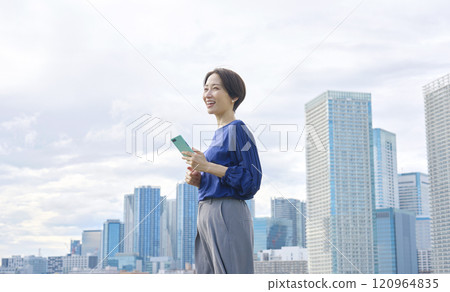 Woman holding a smartphone outdoors Woman holding a smartphone outdoors 120964835