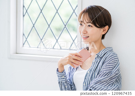 操作智能手機的中年婦女。 操作智能手機的中年婦女。 120967435