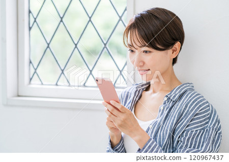 A middle-aged woman who operates a smartphone. 120967437