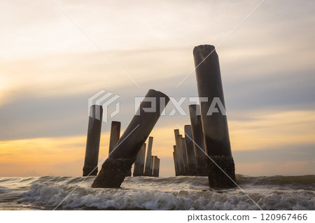 A beautiful sunrise at old leaning cement pillars Cha-Am beach, Phetchaburi, Thailand. 120967466