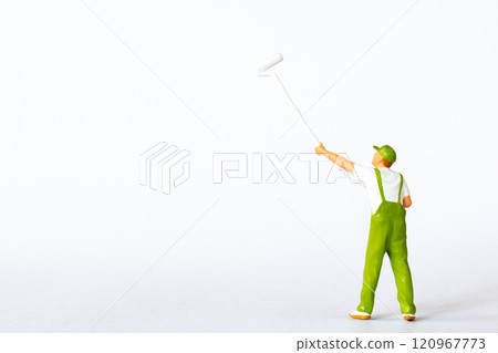 A miniature figure of a painter using a long roller brush to paint on a white background A miniature figure of a painter using a long roller brush to paint on a white background 120967773