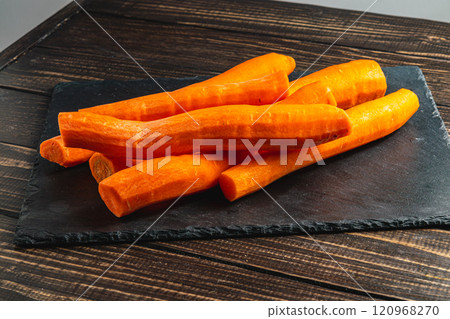 Washed fresh carrots on a stone board on a wooden table Washed fresh carrots on a stone board on a wooden table 120968270