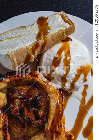Homemade apple pie with ice cream and caramel sauce on a black background Homemade apple pie with ice cream and caramel sauce on a black background 120968275