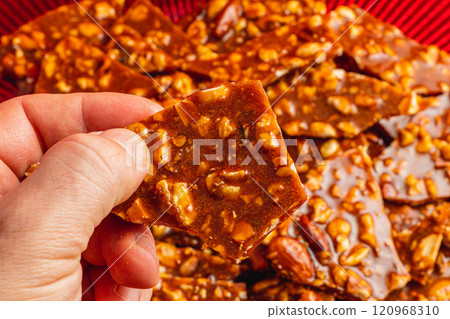 Homemade sugar cookies with nuts in a man's hand with a blurred background Homemade sugar cookies with nuts in a man's hand with a blurred background 120968310