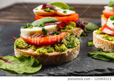 Healthy eating concept, rice cakes with avocado, mozzarella, spinach and onion Healthy eating concept, rice cakes with avocado, mozzarella, spinach and onion 120968323