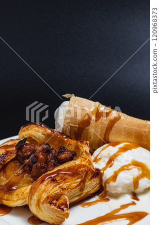 Delicate puff pastry with apples, ice cream and caramel syrup, snack concept Delicate puff pastry with apples, ice cream and caramel syrup, snack concept 120968373