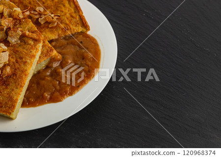 Oven-baked potato pancakes with mushroom sauce and onions on a stone board Oven-baked potato pancakes with mushroom sauce and onions on a stone board 120968374