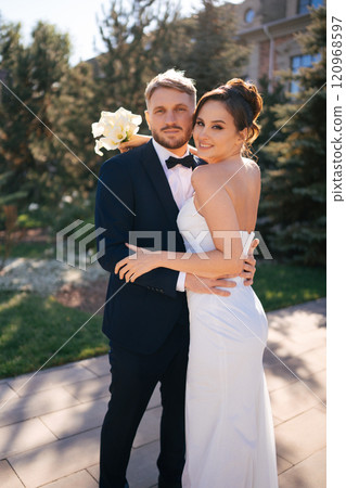 bride and groom cuddling in the autumn park on the territory of the hotel bride and groom cuddling in the autumn park on the territory of the hotel 120968597