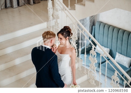 Beautiful and happy bride and groom on a large beautiful staircase. Beautiful and happy bride and groom on a large beautiful staircase. 120968598